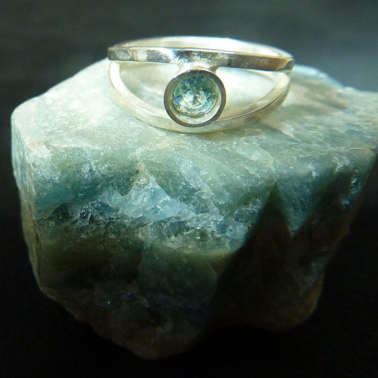 aquamarine ring on top of raw aquamarine stone